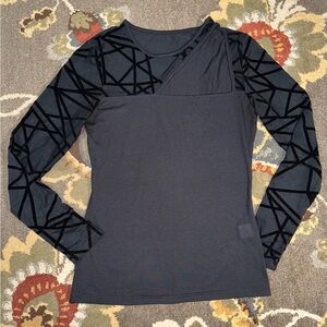 bold geometric velvet mesh sleeves and a unique asymmetrical neckline blouse